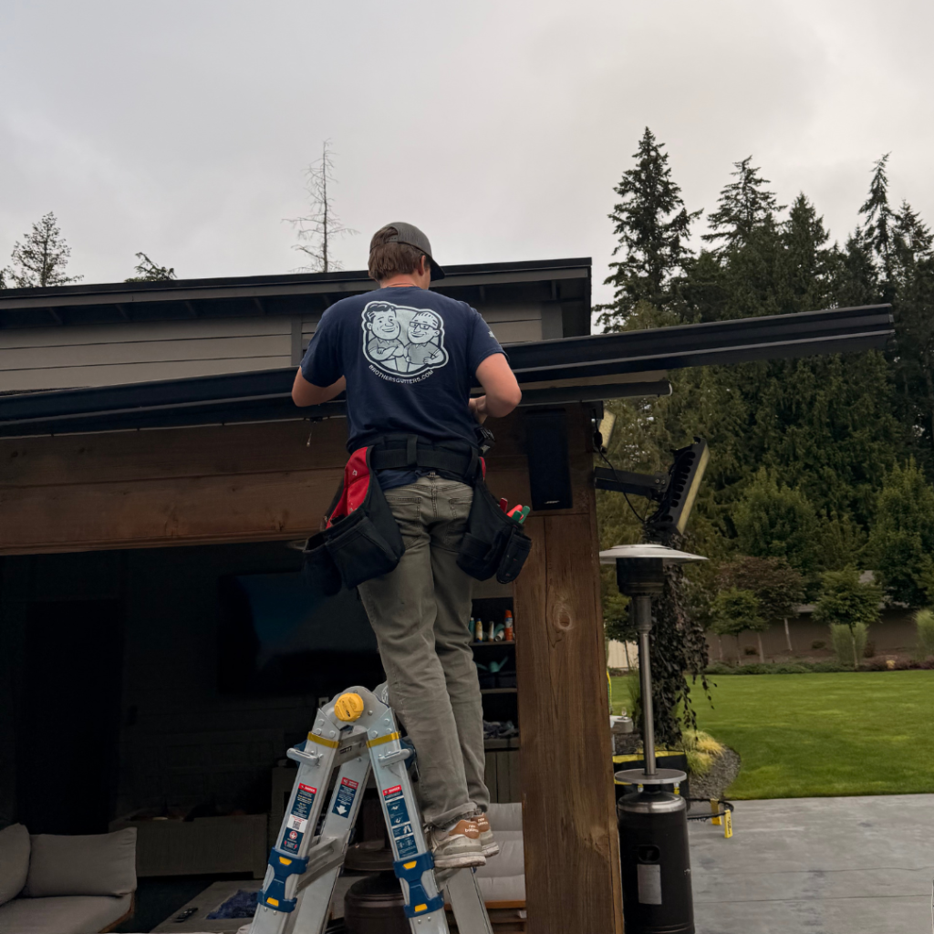 Seamless gutters wrapped around a detached backhouse in the South Sound