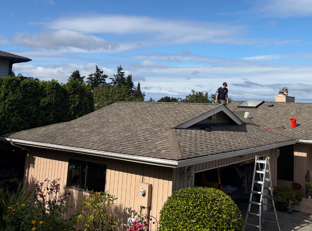 Crew on the roof with the ladder set at the eave