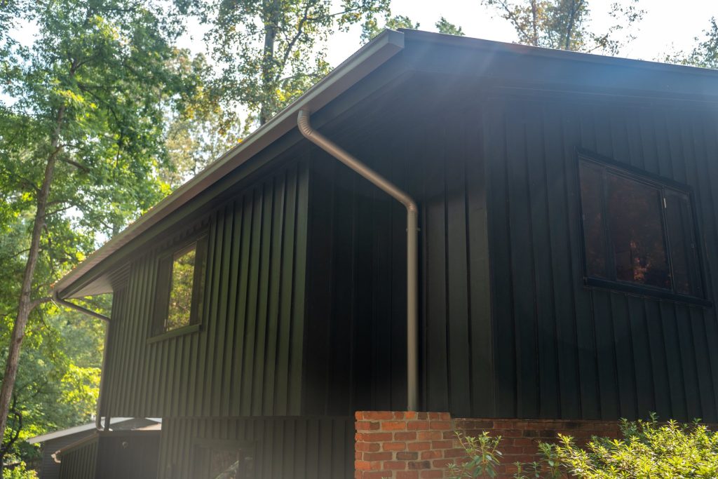 Dark gutters and a downspout on a board-and-batten home